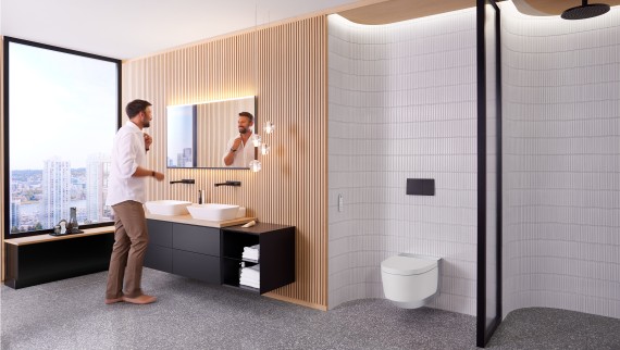Homme dans une salle de bains devant le miroir Geberit Option Plus Square et des meubles de salle de bains Geberit ONE noirs (© Geberit) Homme dans une salle de bains devant le miroir Geberit Option Plus Square et des meubles de salle de bains Geberit ONE noirs (© Geberit)