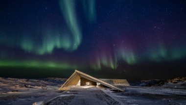 Le Centre Icefjord sous les spectaculaires aurores boréales de la nuit polaire groenlandaise (© Adam Mørk)